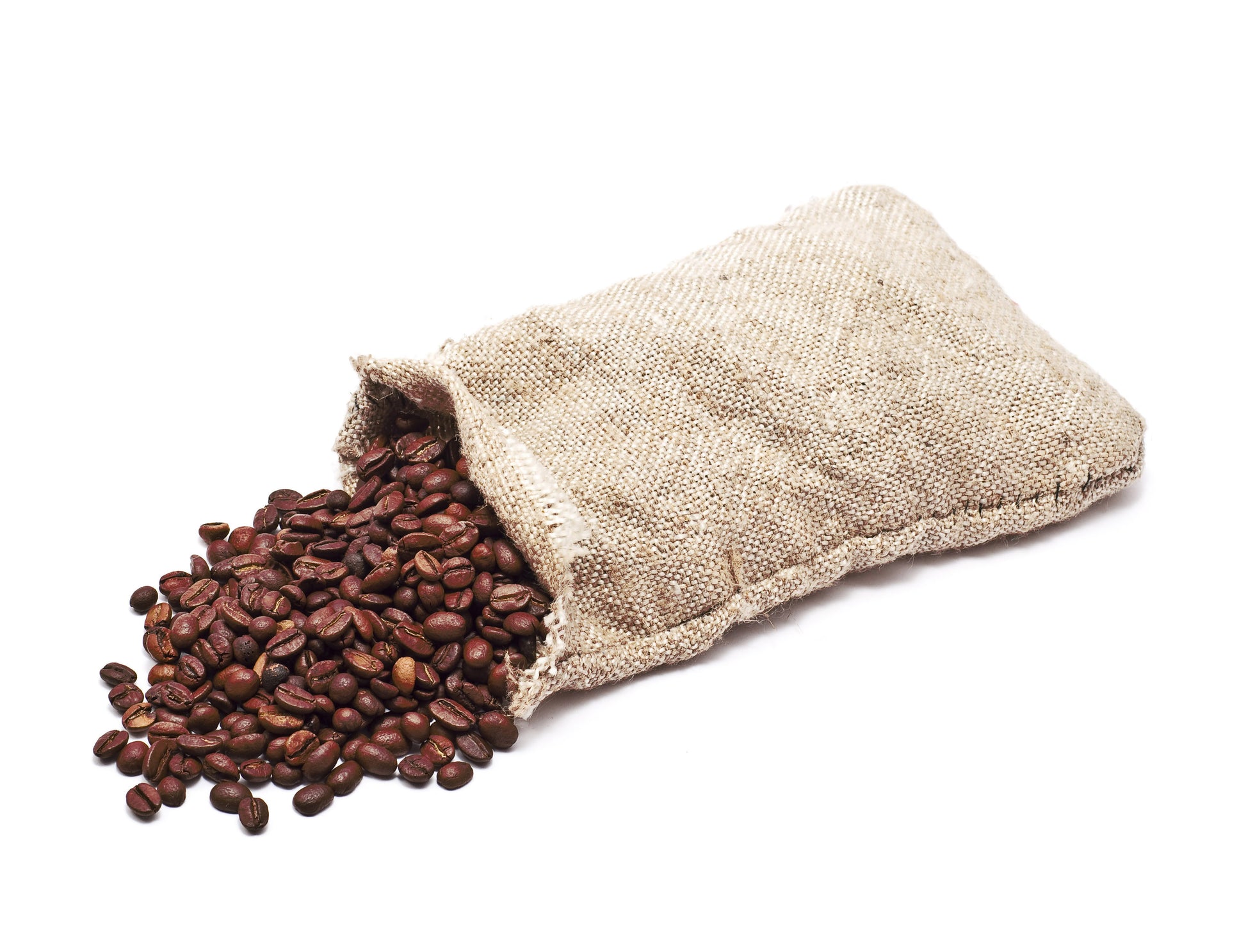 Open beige fabric bag spilling out coffee beans on a white background